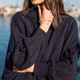 Navy blue ruffled knit wrap with textured weave and long sleeves.