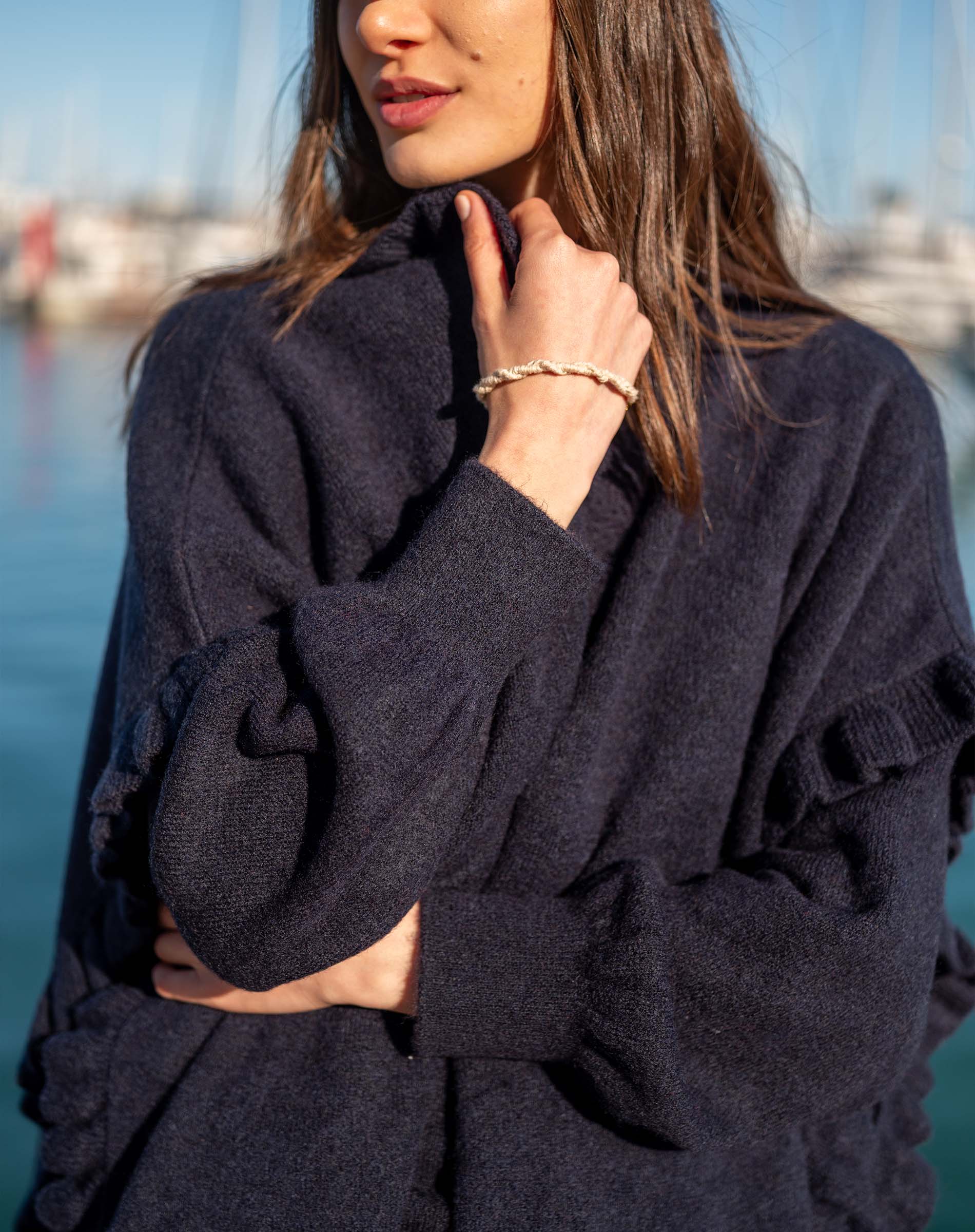 Navy blue ruffled knit wrap with textured weave and long sleeves.