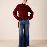 Women's travel-friendly cabernet red knit sweater with ribbed textures and a decorative neckline.