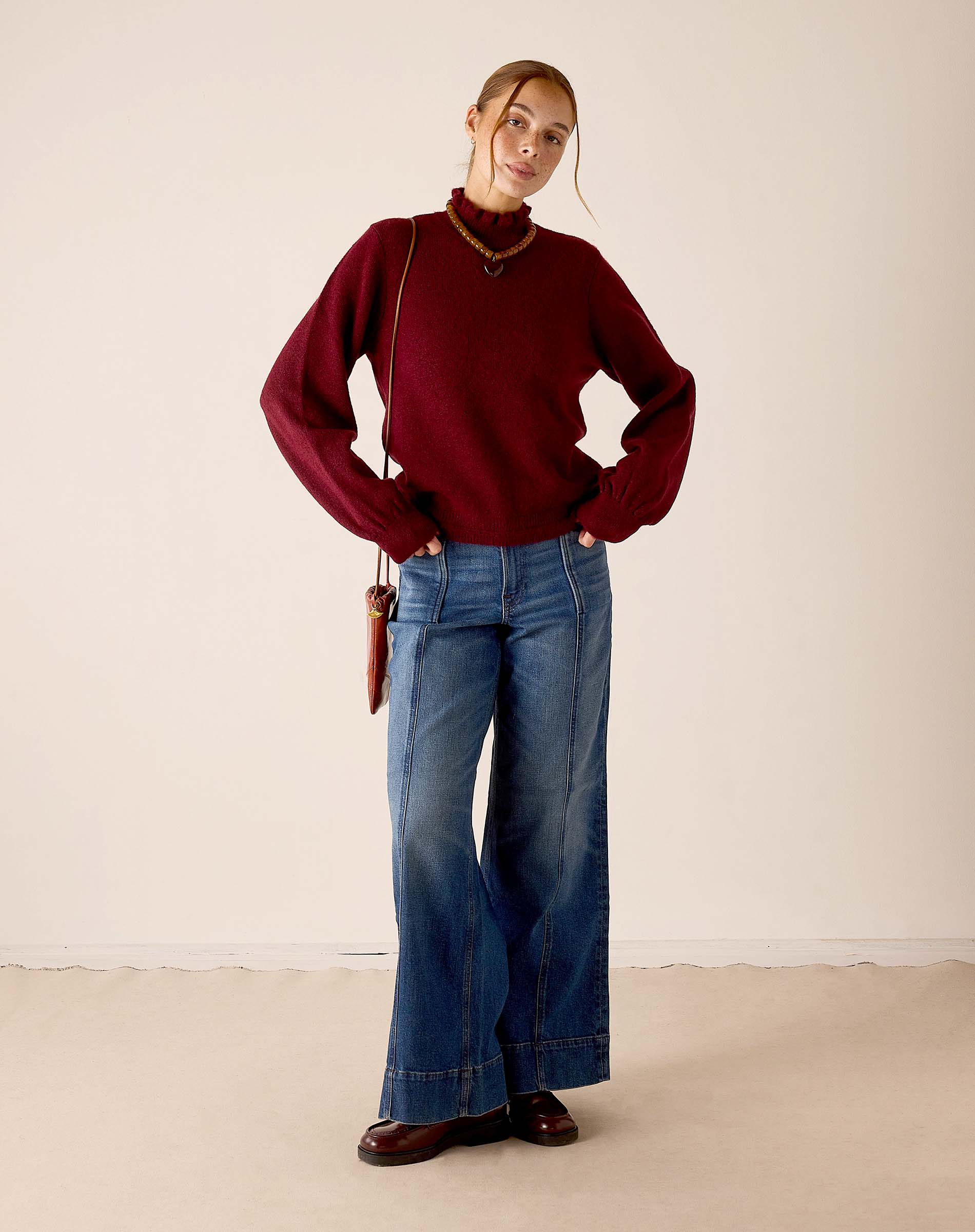 Women's travel-friendly cabernet red knit sweater with ribbed textures and a decorative neckline.
