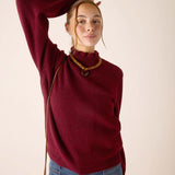 Cabernet red turtleneck knit sweater with a soft ribbed texture.