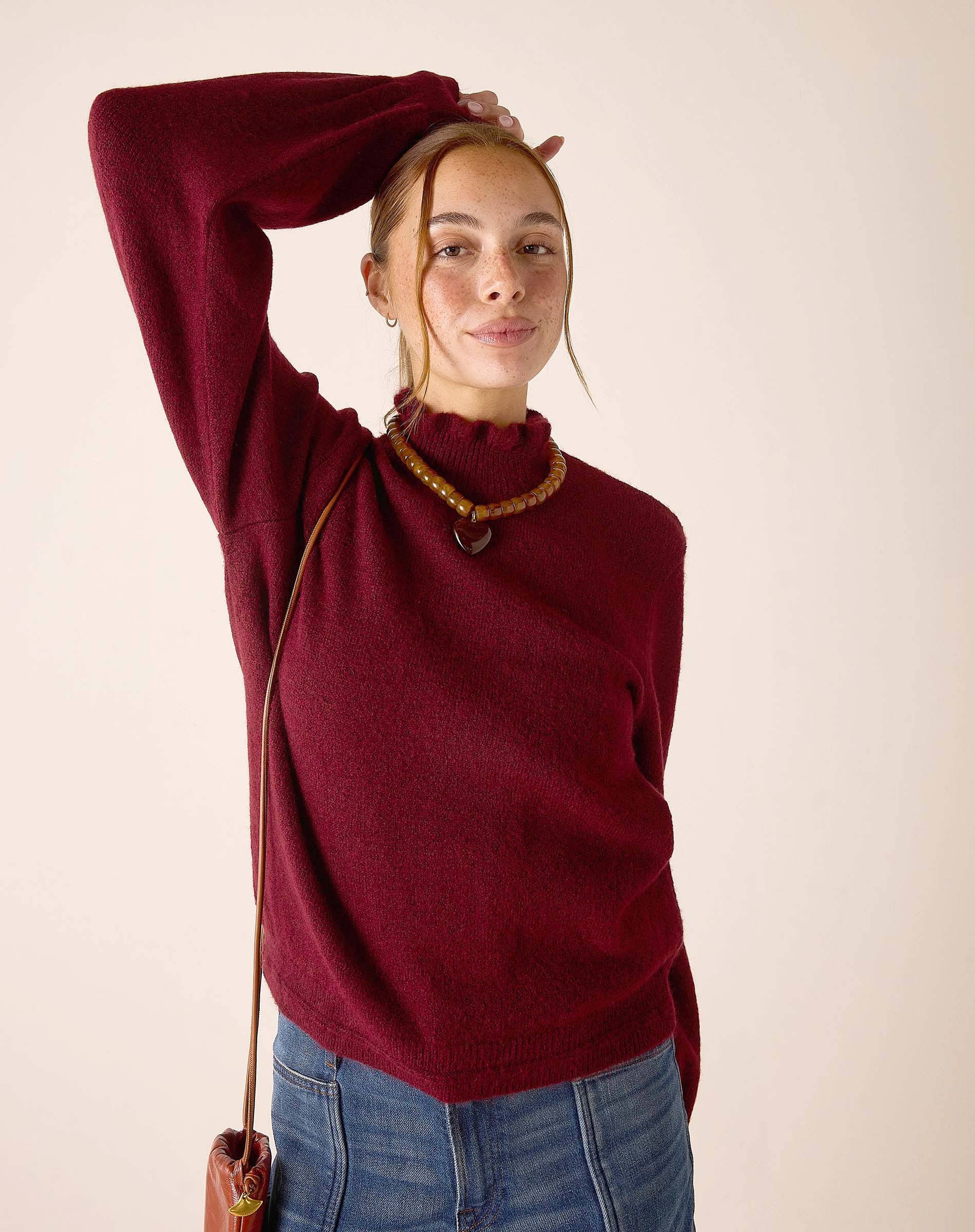 Cabernet red turtleneck knit sweater with a soft ribbed texture.