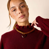 Cabernet red knit turtleneck sweater with a soft textured finish.