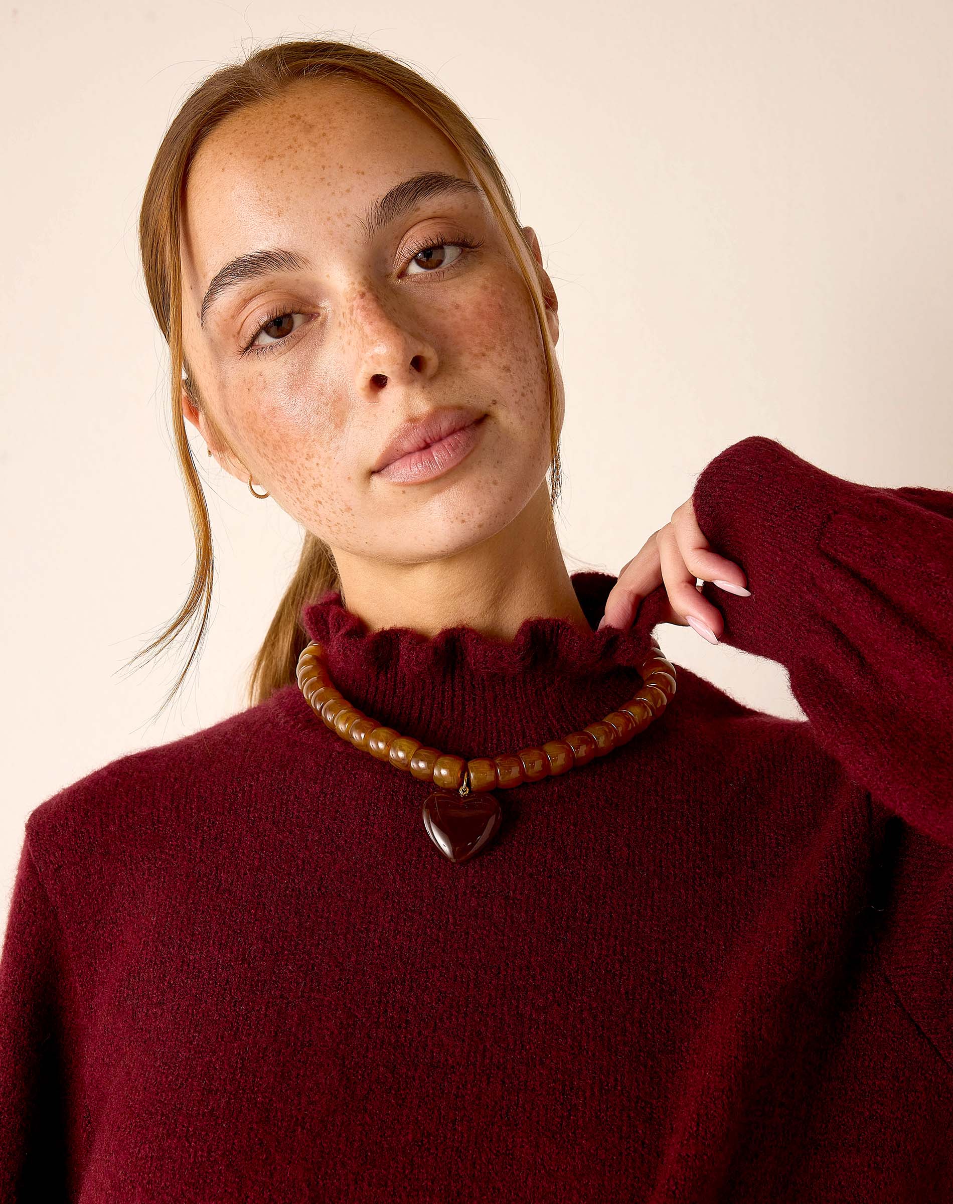 Cabernet red knit turtleneck sweater with a soft textured finish.