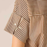 Close-up of a brown and white striped shirt with short sleeves on a beige background