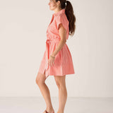 Woman wearing a pink striped dress against a white background