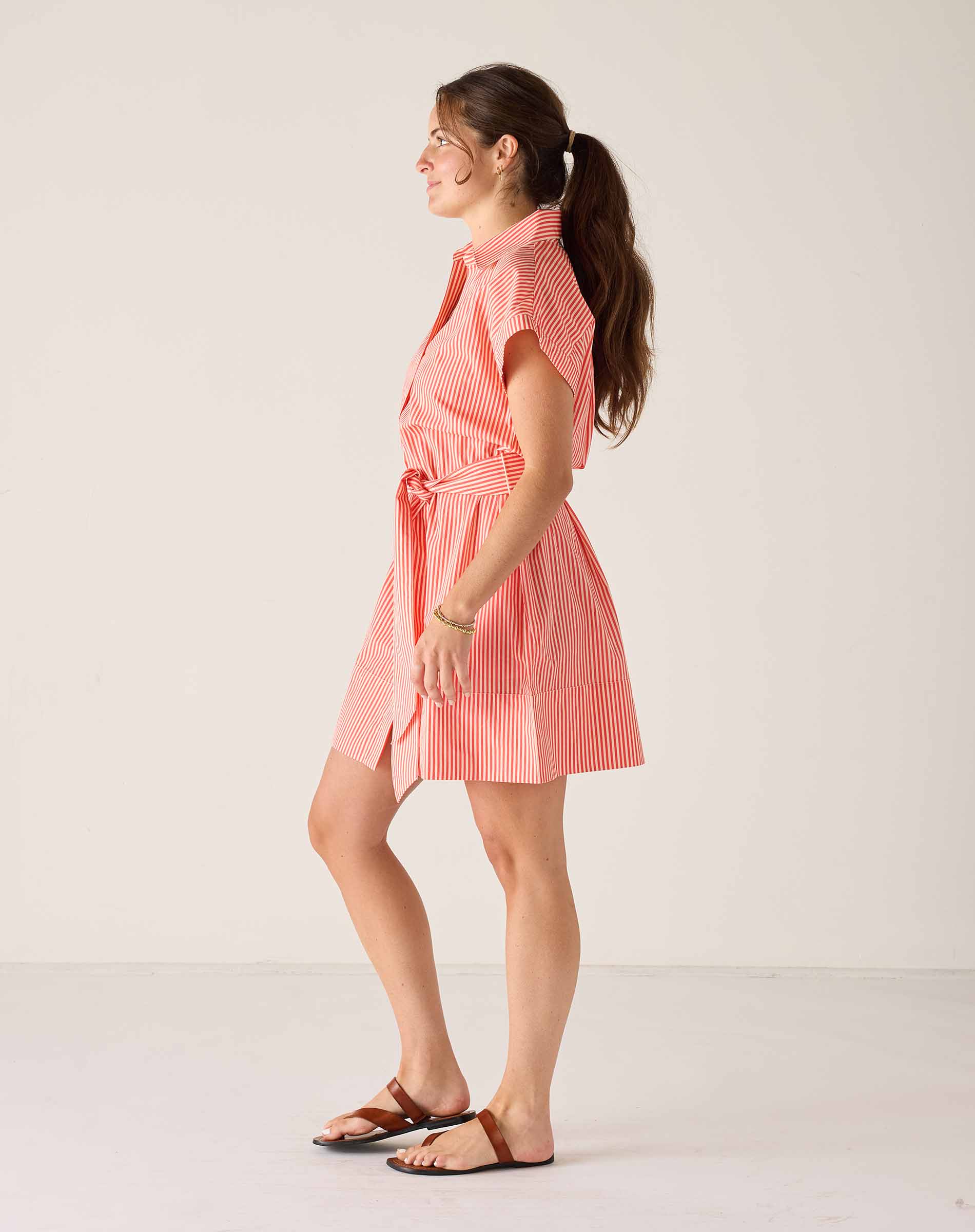 Woman wearing a pink striped dress against a white background