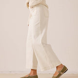 White cropped wide-leg pants in a textured woven fabric with a decorative stitched pocket.