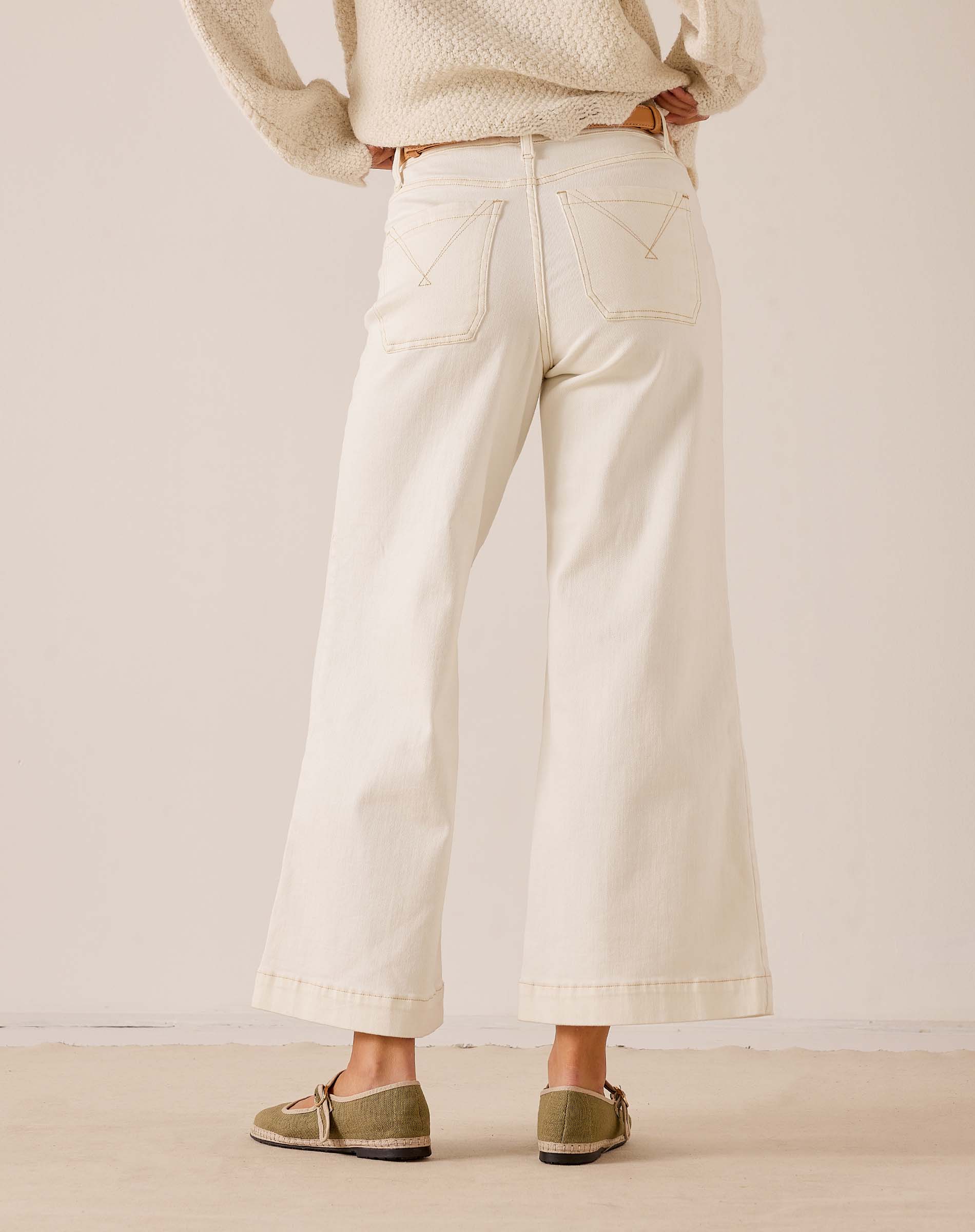 White wide-leg cropped pants made of cotton with decorative stitching on the pockets.