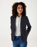 female wearing navy twill peacoat over a white collared shirt with blue jeans on a white background