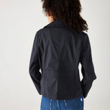 female wearing navy twill peacoat over a white collared shirt with blue jeans on a white background