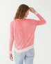 female wearing pink hand-dyed cashmere sweater backwards on a white background
