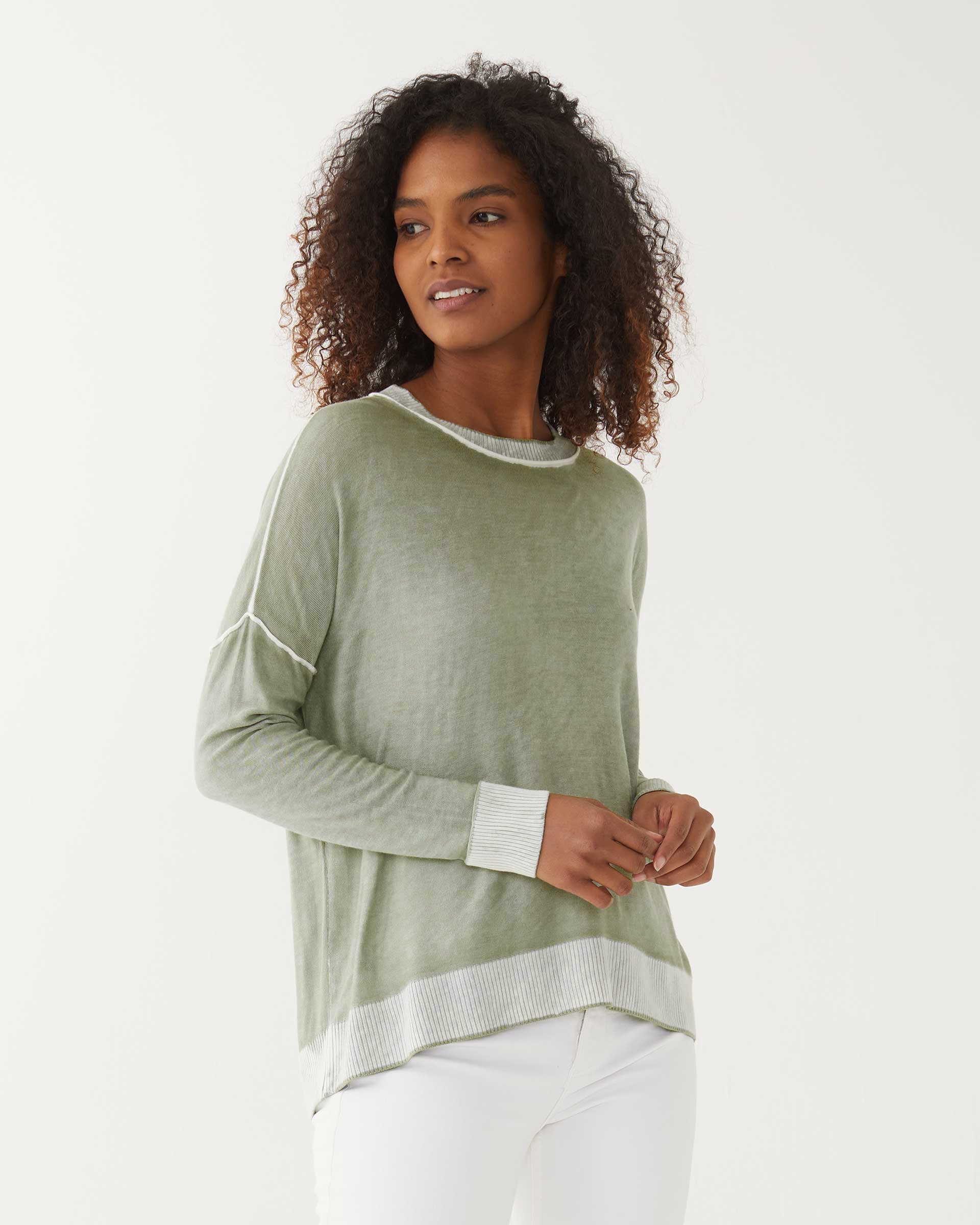 female wearing sea moss green hand-dyed cashmere sweater standing on a white background