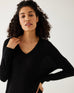 closeup of woman showcasing mersea black long sleeve v neck saltwash sweater dress