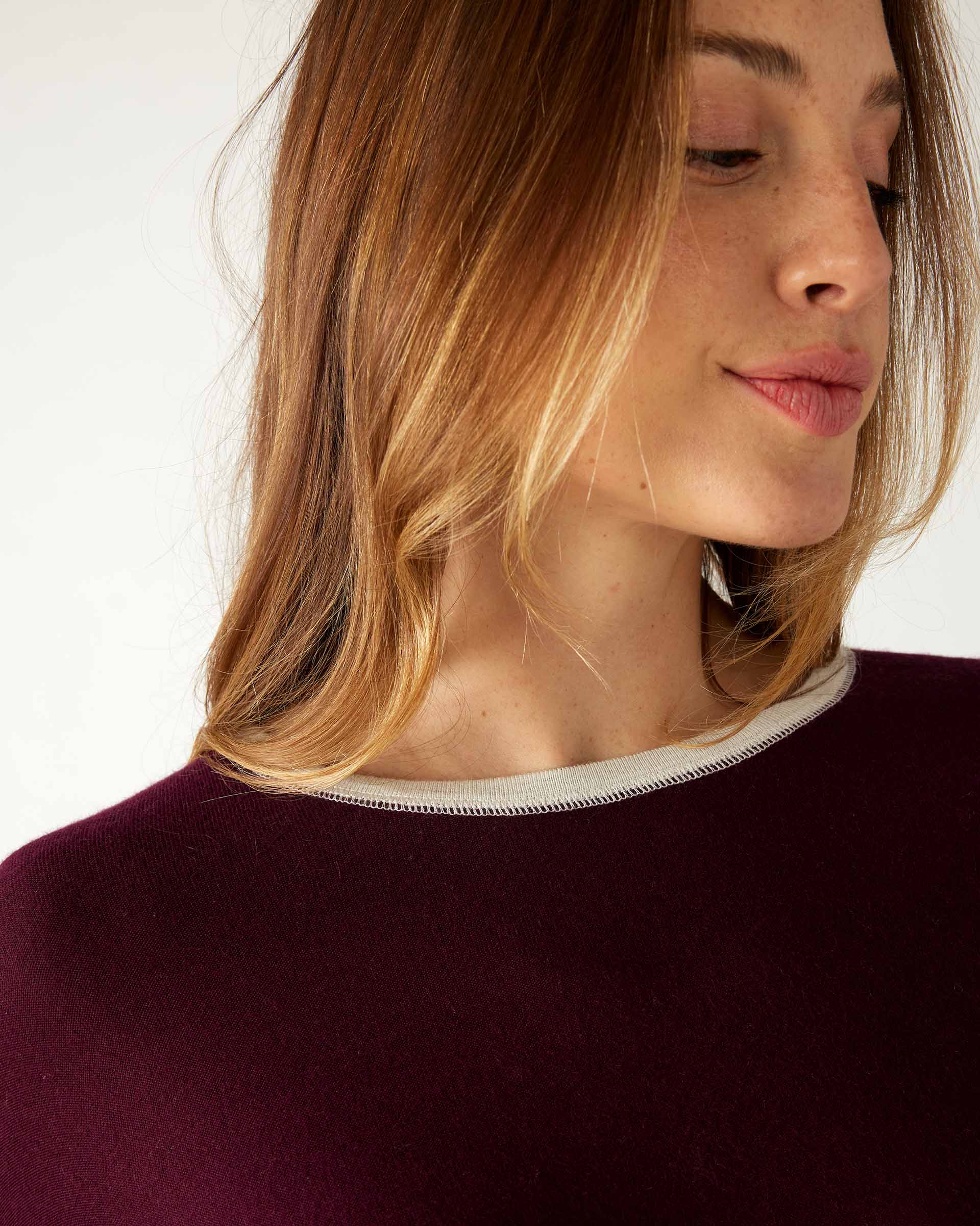 closeup of collar on woman wearing mersea saltwash sweater in cabernet red