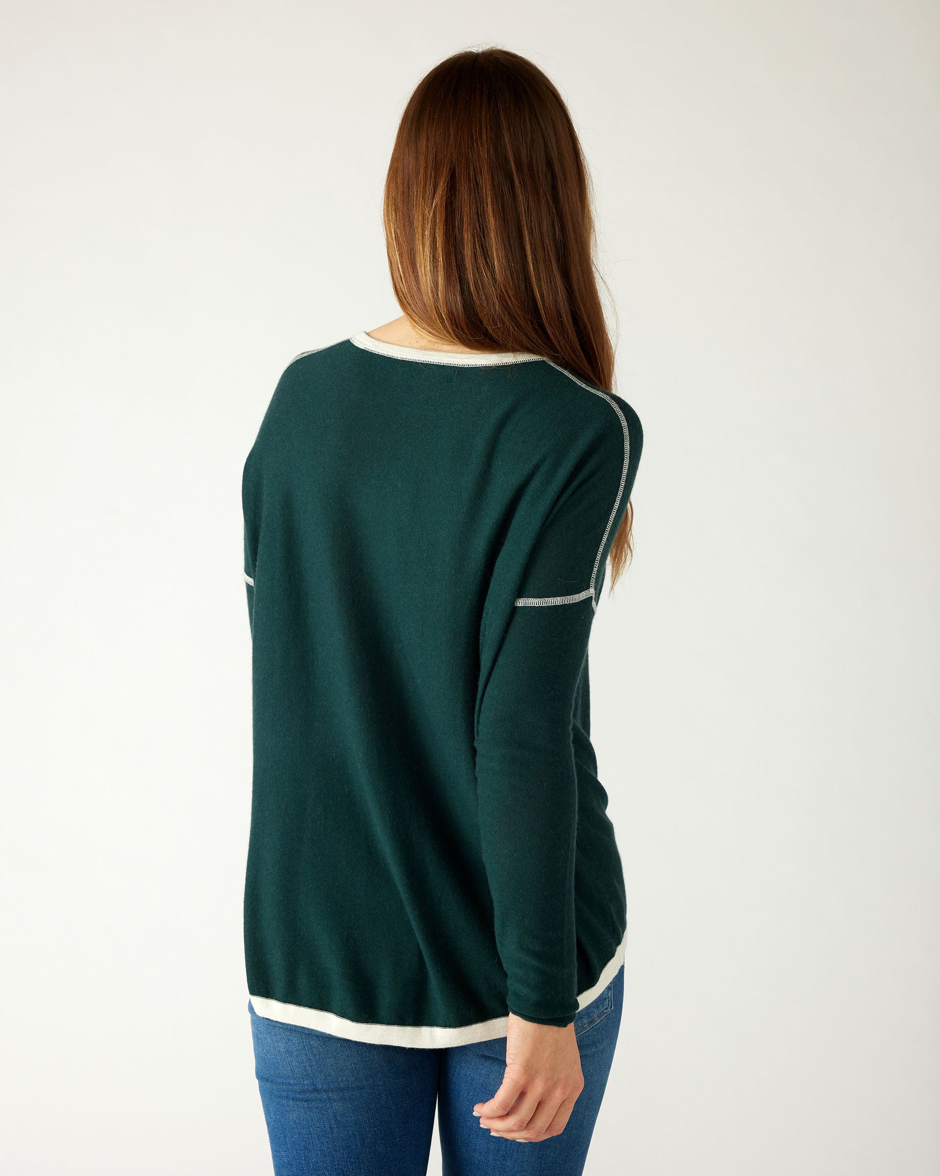 rear view of woman wearing mersea saltwash sweater in forest green