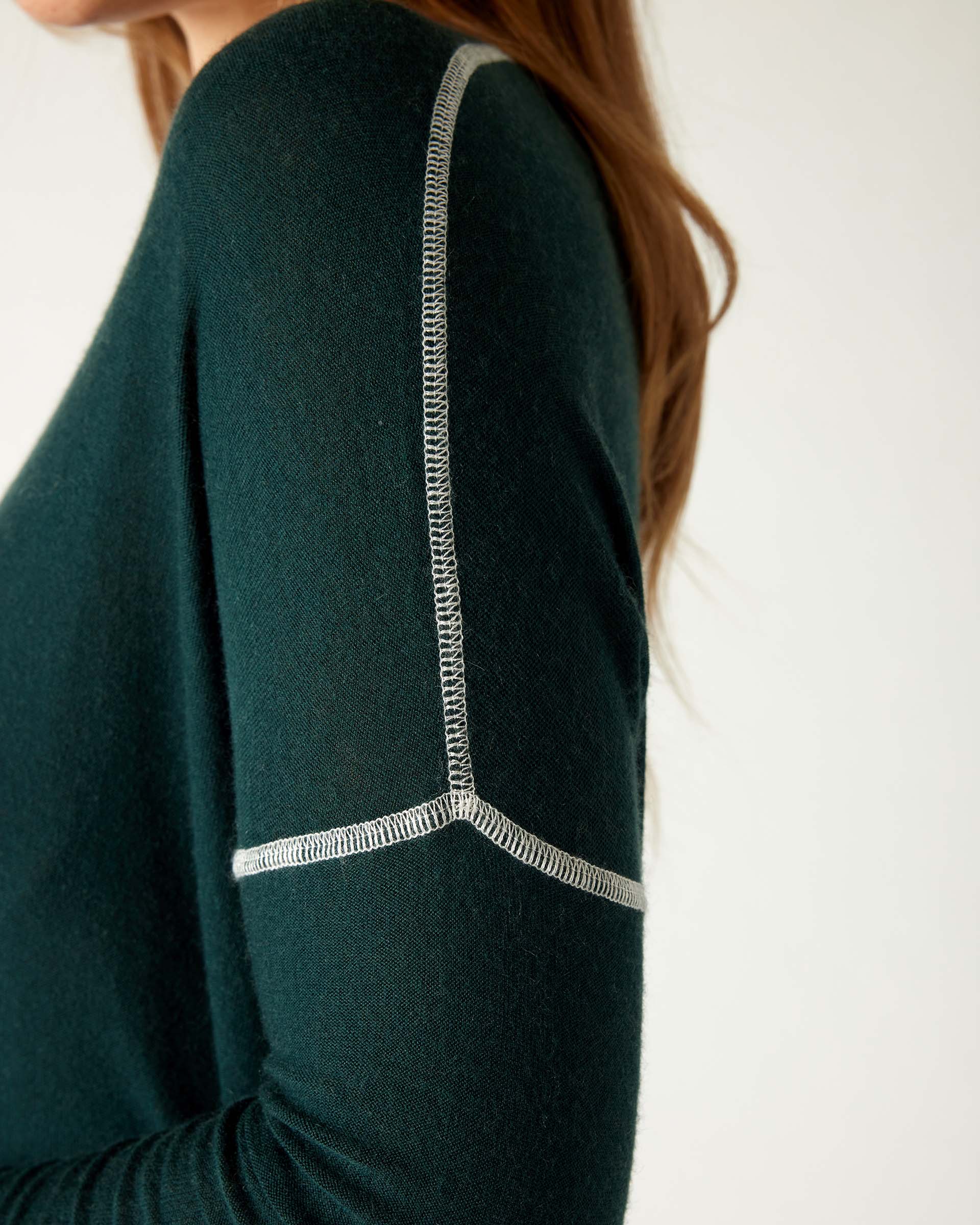 closeup of shoulder detail on woman wearing mersea saltwash sweater in forest green