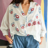 Woman wearing a floral blouse with a colorful background