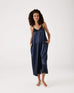 female wearing Mersea sapphire satin jumpsuit standing against white background