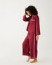 female wearing Mersea garnet satin sailor pajama set standing sideways against white background