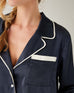 closeup of top of Mersea sapphire satin sailor pajama set on female against white background
