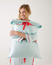 female holding Mersea aquamarine satin sailor pillowcase against white background
