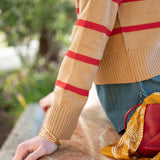 Cappuccino and crimson striped knit sweater with ribbed cuffs.