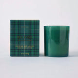 MERSEA ladies' travel-ready sea Pines scented soy candle in a dark green glass jar next to its matching plaid box. Text: SEA PINES SCENTED SOY CANDLES BOISE DE SEA IMPRIMÉ 10 oz | 283 g