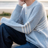 Soft sky white knit sweater with textured ribbed details and wide horizontal stripes.