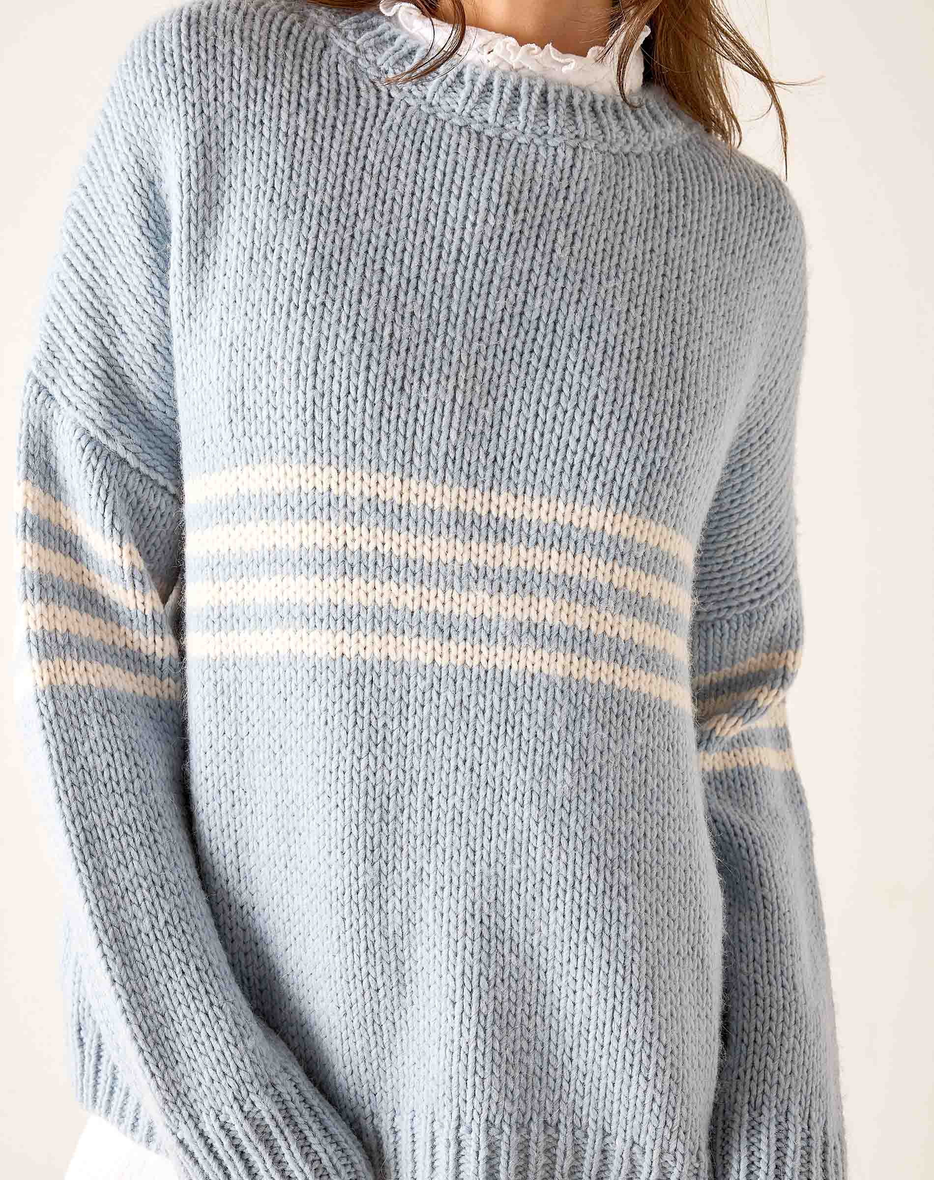 Soft sky white knit sweater with horizontal stripes in a light blue and cream palette.
