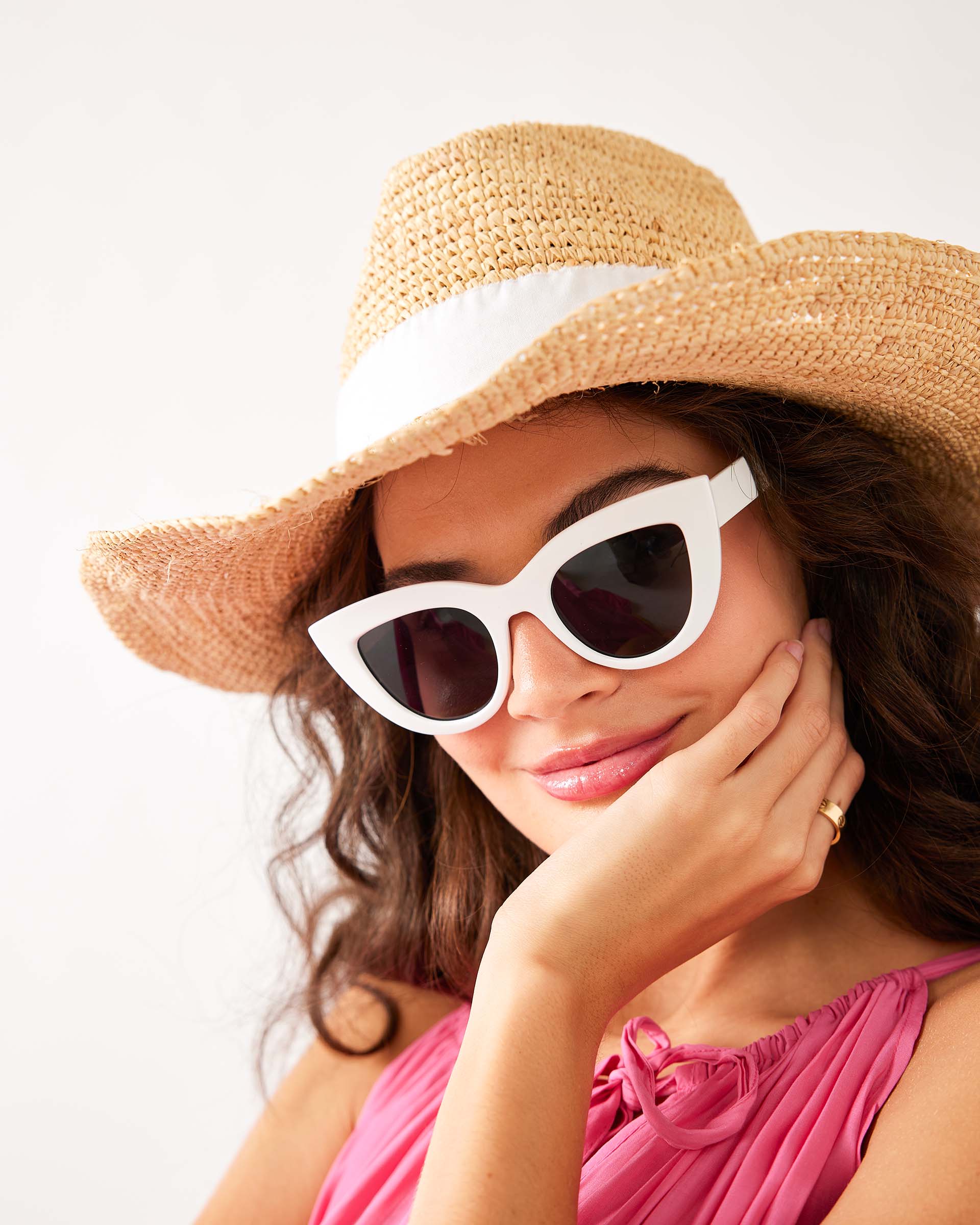 woman wearing sunglasses in a pink dress with mersea seagrove straw hat on