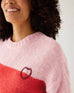 closeup of heart on  woman wearing mersea seahappy heart holiday sweater in bliss pink stripes
