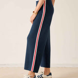 Navy knit pants with white and red stripes on the side.