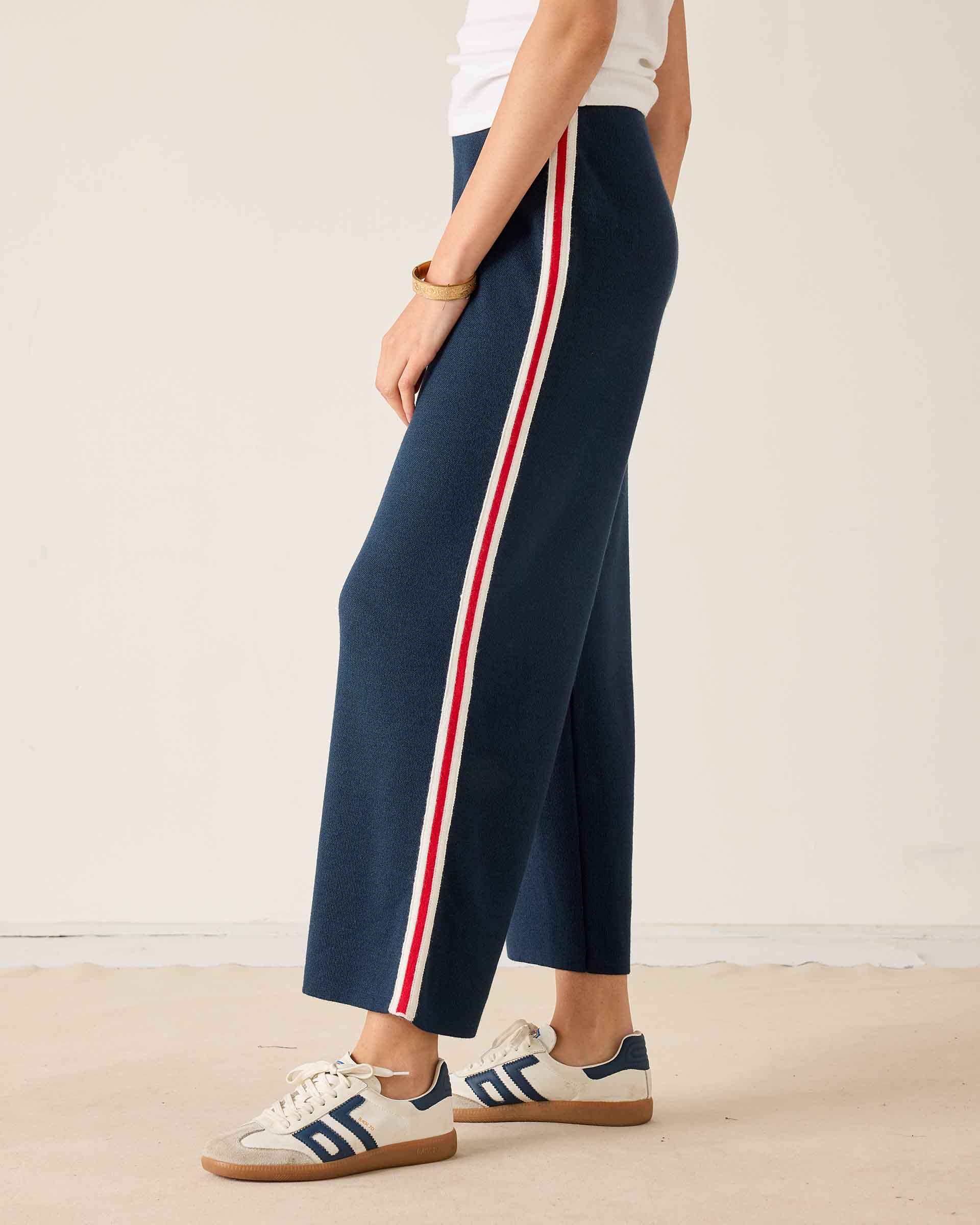 Navy knit pants with white and red stripes on the side.