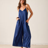 Woman wearing a blue slip dress against a plain background