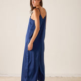Woman wearing a blue slip dress on a plain background