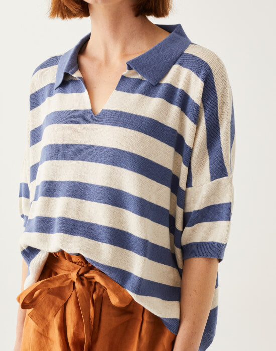 female wearing blue & white striped polo sweater with clay linen shorts on white background