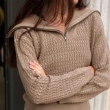 Woman wearing a beige knitted sweater with a zipper
