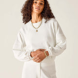Woman wearing a white outfit with a plain background