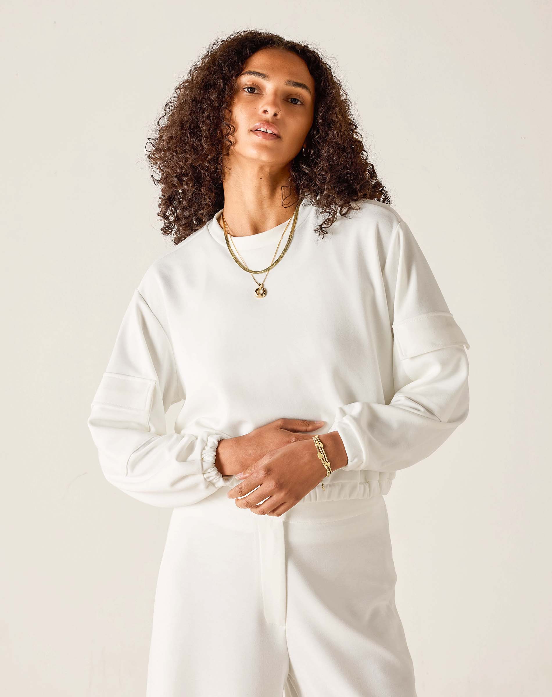 Woman wearing a white outfit with a plain background