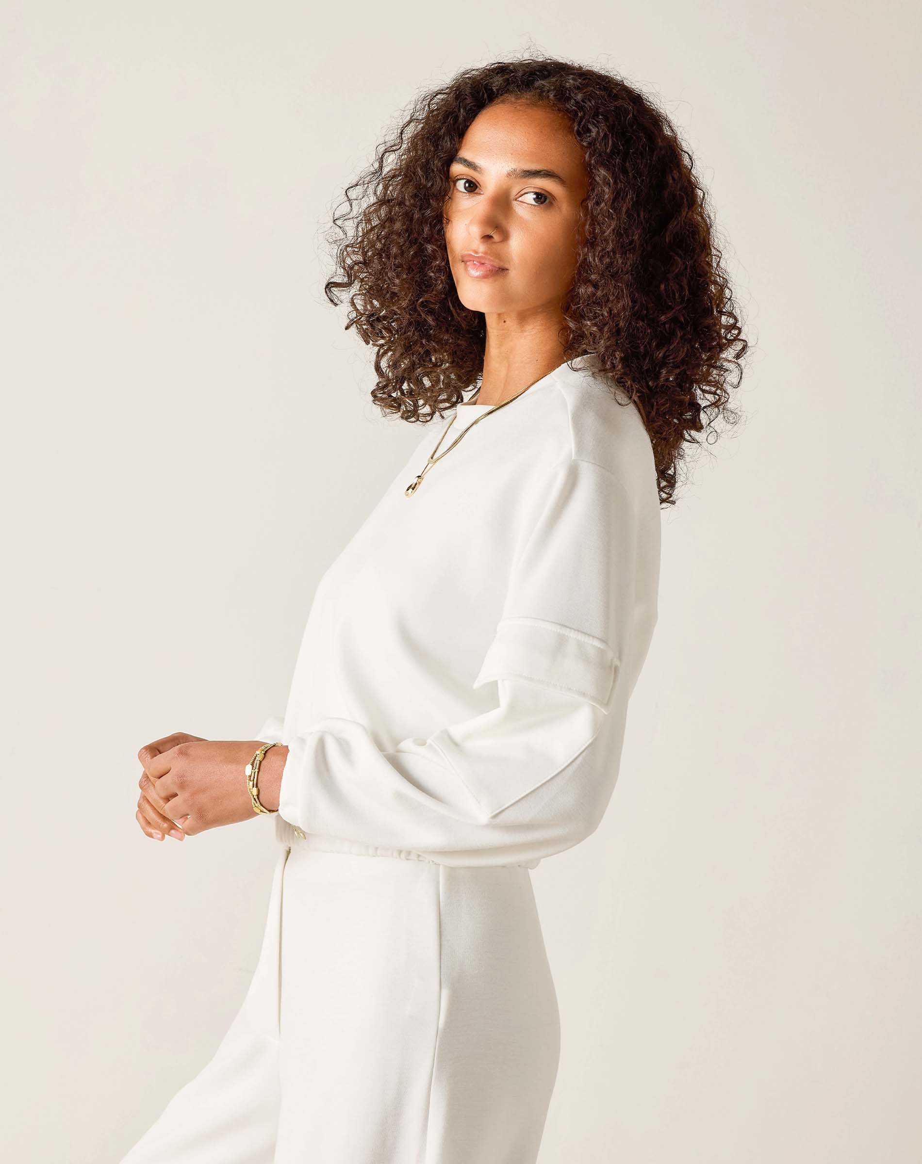 Woman wearing a white outfit against a plain background