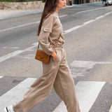 Woman in beige outfit crossing a street