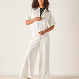 Person wearing a white outfit with a plain background