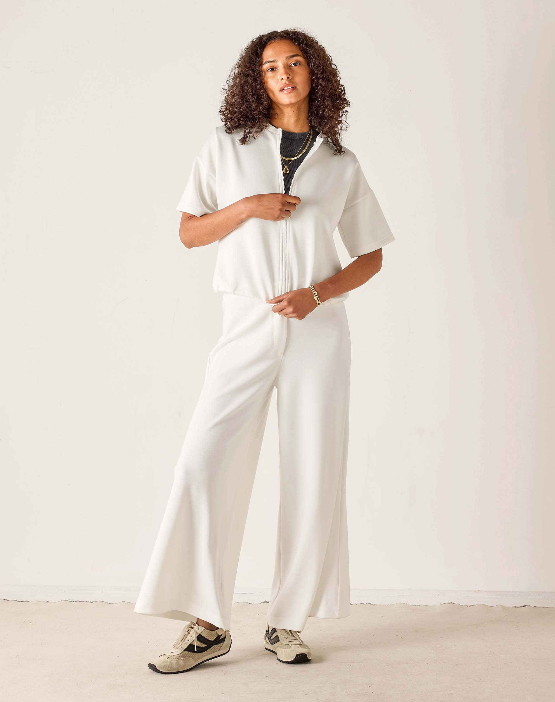 Person wearing a white outfit with a plain background