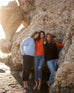 three women wearing mersea sol mate crewneck pullovers in snowflake tangerine and navy standing together against rocks