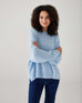 woman showcasing mersea sol mate crewneck pullover in snowflake standing with arms crossed
