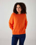 upper body of woman showcasing mersea sol mate crewneck pullover in tangerine