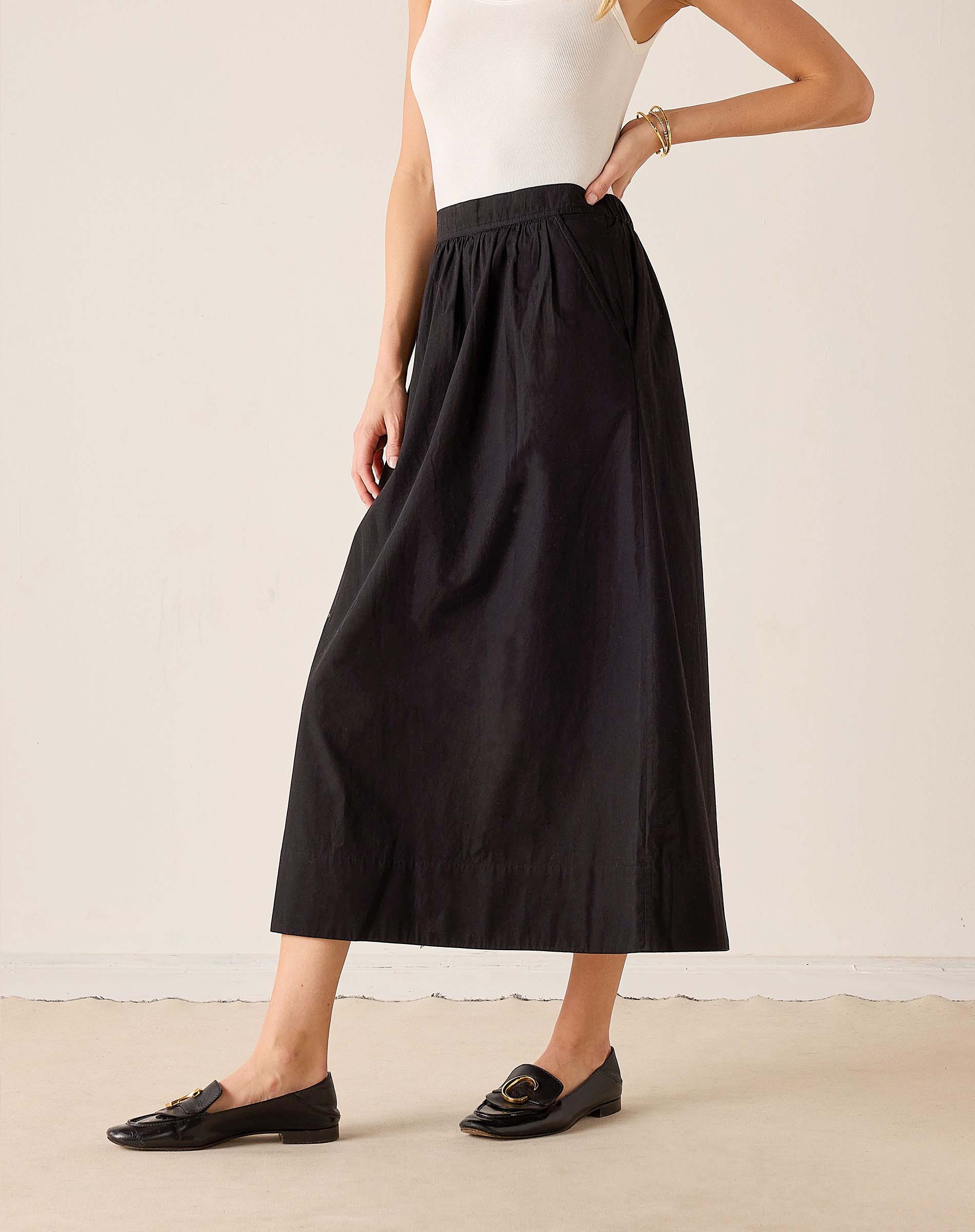 Black maxi skirt in a lightweight woven fabric with a full, flowing silhouette and wide-leg drape.