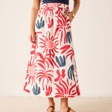 Person wearing a colorful patterned skirt on a plain background