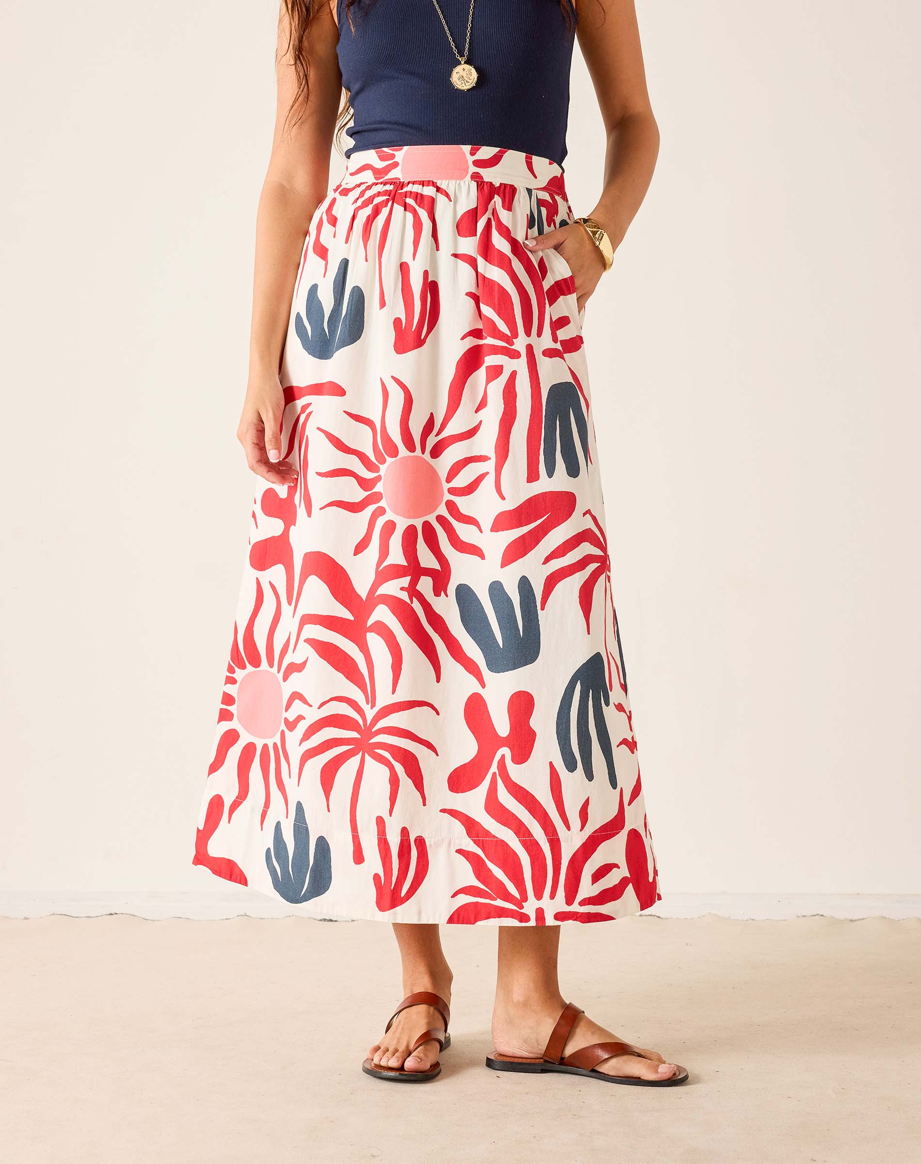 Person wearing a colorful patterned skirt on a plain background